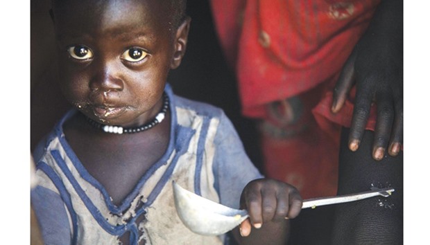 A boy eats out of a ladle at his home in Ngop in South Sudanu2019s Unity State. The Norwegian Refugee Council (NRC) distributed food (maize, lentils, oil and corn soya blend) for more than 7,100 people in Ngop. South Sudan, the worldu2019s youngest nation formed after splitting from the north in 2011, has declared famine in parts of Unity State, saying 100,000 people face starvation and another million are on the brink of famine.