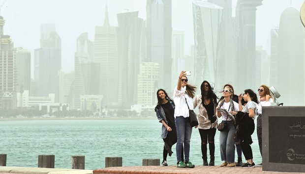 People clicking a selfie against the backdrop of a dust-engulfed West Bay skyline yesterday. PICTURE: Noushad Thekkayil