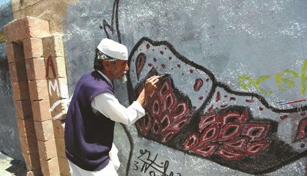 A man works on a mural on the southern wall of Sanaau2019s University in the Yemeni capital during the Open Day of Art annual event yesterday.
