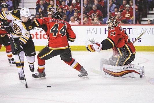 Boston Bruinsu2019 Brad Marchand (left) scores past Calgary Flames goalie Chad Johnson (right) during the NHL game in Calgary, Canada. (USA TODAY Sports)