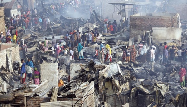 Slum dwellers search for valuables after a devastating fire destroyed their shanties in the Bangladesh capital, Dhaka. 