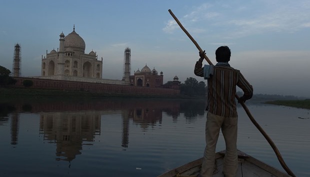 An Indian boatman rows his boat on the Yamuna River behind the Taj Mahal in Agra.