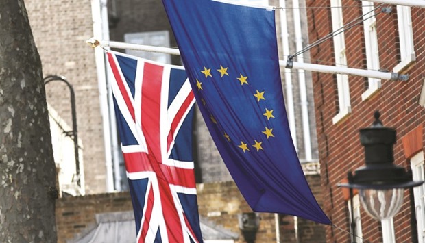 The Union Jack (left), flies next to a European Union (EU) flag outside Europa House in London. In a sign the EU is toughening its stance as Britain prepares to trigger two years of Brexit negotiations with the EU, two European officials familiar with the plan said in the best-case scenario it may take until early 2018 to find common ground on the bill to settle the UKu2019s liabilities.