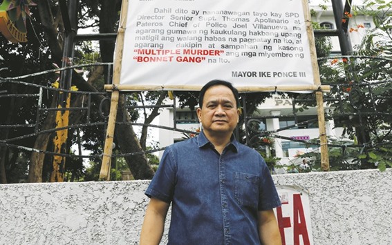 Filipino Mayor Ike Ponce poses in front of a banner denouncing the Bonnet Gang, outside the municipal hall in the town of Pateros, Metro Manila.