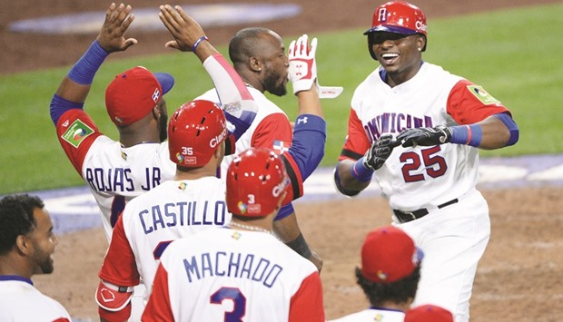 Dominican Republic outfielder Gregory Polanco (R) is congratulated after hitting a one run home run against the Venezuela.