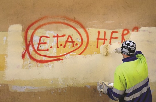 This picture taken on October 21, 2011 shows a municipal worker paints over graffiti reading u2018ETA, The People Are With Youu2019 in the Basque town of Guernica, Spain, the day after Basque separatist group ETA announced a definitive cessation of armed activity.
