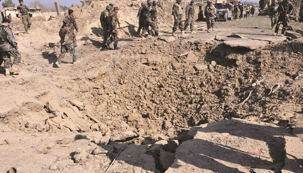 Afghan security personnel stand alert near a crater after a car bomb exploded which targeted an Afghan National Army (ANA) base in Khost province yesterday.