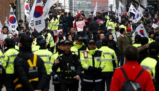 Police officers stand guard while supporters of South Korea's ousted leader Park Geun-hye wait in Seoul