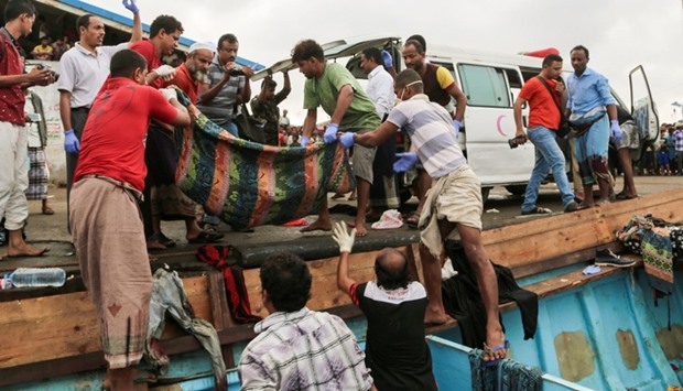 Yemeni officers carry the bodies of Somali refugees, killed in attack