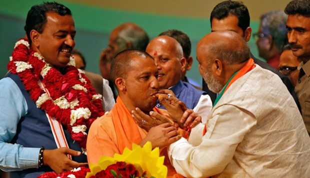 Indiau2019s ruling Bharatiya Janata Party (BJP) leader Yogi Adityanath (C) is offered sweets after he was elected as Chief Minister of Indiau2019s most populous state of Uttar Pradesh, during the party lawmakers' meeting in Lucknow.