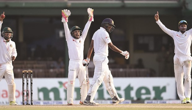 Bangladeshu2019s Sabbir Rahman (L), captain Mushfiqur Rahim (C) and fielder Shakib Al Hasan (R) unsuccessfully appeal for the wicket of Sri Lankan batsman Suranga Lakmal (2R) during the fourth day of the second Test in Colombo yesterday. (AFP)