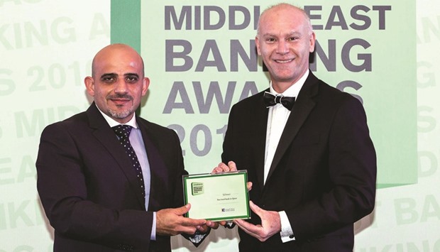 El-Zagha (left) receives the u2018Best local bank in Qataru2019 award on behalf of Doha Bank.