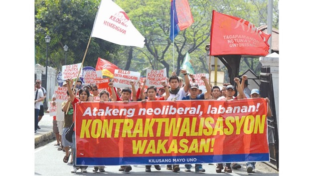 Workers hold banners as they march towards the Department of Labour and Employment (DOLE) office for a rally in Manila.