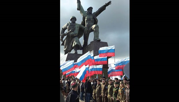 People wave Russian flags as they celebrate the third anniversary of the annexation of the Crimea in Sevastopol.