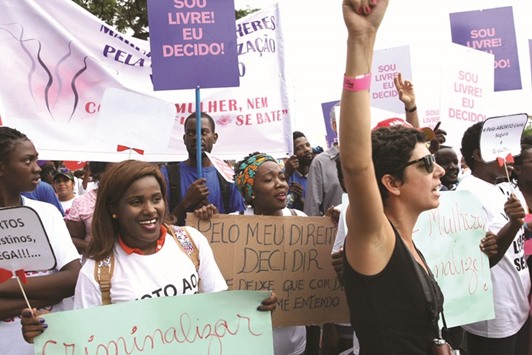 Angolans hold placards and shout slogans during their protest in Luanda against a draft law that would criminalise abortion.