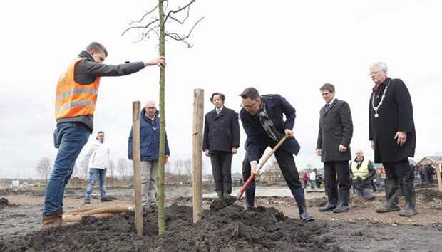 Dutch Foreign Minister Bert Koenders (fourth from left) observes as a tree is planted at the national monument for the victims of flight MH17, in Vijfhuizen.