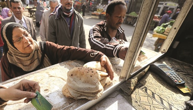 People buy bread at a bakery in Cairo on March 9. The pound has weakened by about 50% since the November 3 float, helping to send the inflation rate above 30% in February. Thatu2019s hurting incomes and forcing Egyptians to spend more of their incomes on basic necessities.
