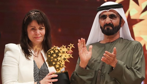 Canadian teacher Maggie MacDonnell (L) receives the Global Teacher Prize from Sheikh Mohammed bin Rashid al-Maktoum, vice-president and Prime Minister of the UAE and Ruler of Dubai, during a ceremony in Dubai .