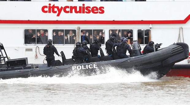 Armed counter terrorism officers of the London Metropolitan Police, take part in a training exercise to rescue hostages, played by actors, from a cruise boat on the river Thames, in London, yesterday.