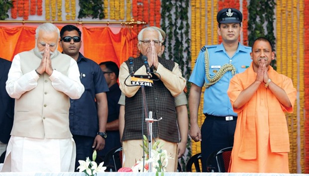 Prime Minister Narendra Modi, Uttar Pradesh Governor Ram Naik Yogi Adityanath greet a gathering before Adityanath takes an oath as the new chief minister of Uttar Pradesh yesterday.