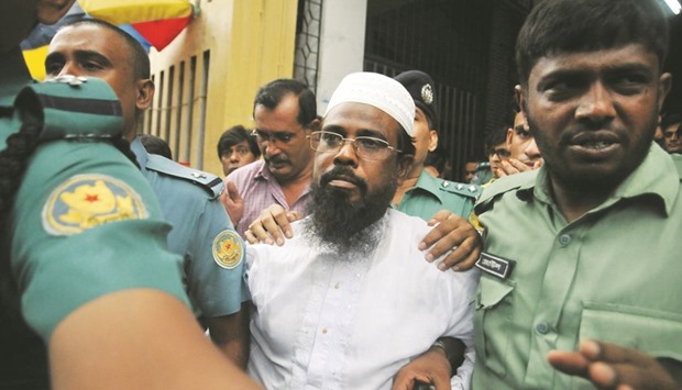Mufti Abdul Hannan, flanked by police officers after a court appearance in Dhaka.