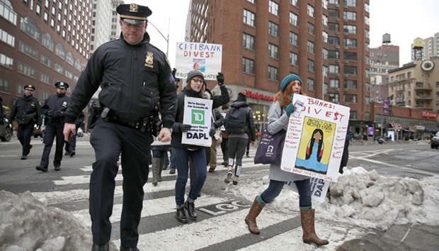 Police follow activists as they march in protest against banks funding the Dakota Access Pipeline during a Divestment Day rally in the Manhattan borough of New York.
