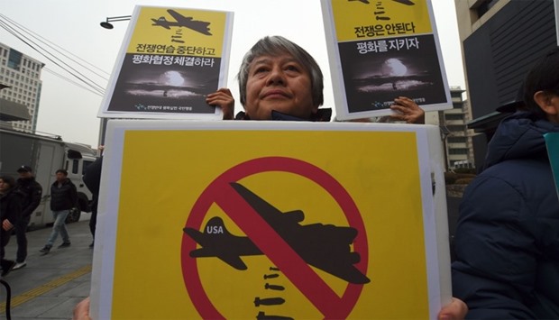 Activists hold placards during a rally against South Korea-US joint military exercises