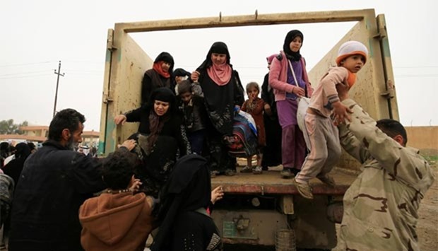 Displaced Iraqi people, who fled their homes during a battle between Iraqi forces and Islamic State militants, arrive at a checkpoint to be transferred to Hammam al-Alil camp in Mosul on Monday.