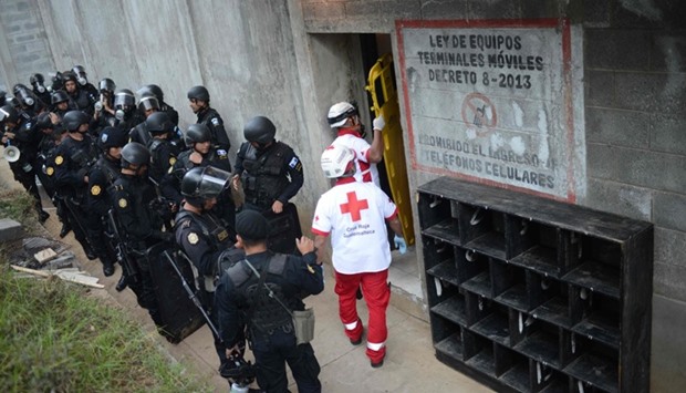 Riot police stand guard outside as Red Cross workers enter a juvenile detention center in San Jose Pinula, east of Guatemala City.