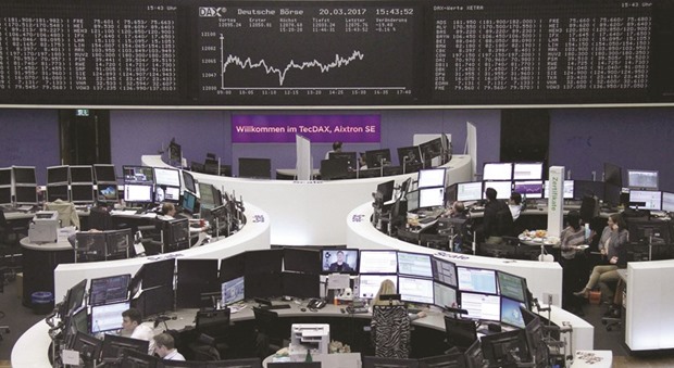 Traders work at the Frankfurt Stock Exchange. The DAX 30 closed down 0.4% to 12,052.90 points yesterday.
