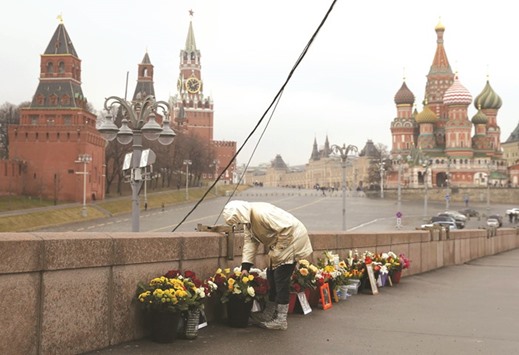 A woman adjusts flowers yesterday at the site of the assassination of Nemtsov in central Moscow.