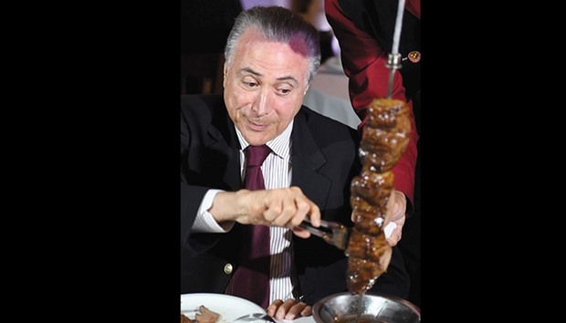 Brazilian President Michel Temer eats at a steak house in Brasilia after meeting with ambassadors from countries that import Brazilian meat.