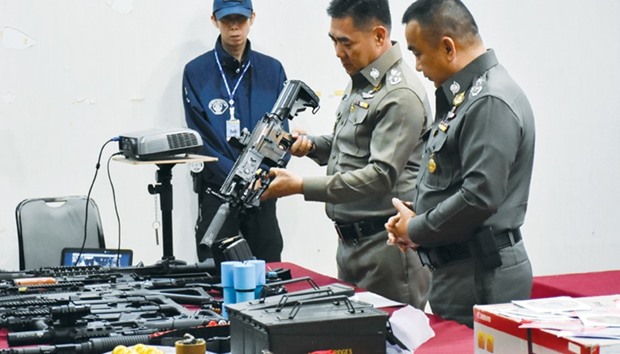 Thailandu2019s national police chief Jakthip Chaijinda holds a confiscated weapon during a news conference at the Royal Thai Police headquarters in Bangkok.