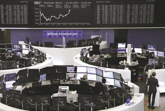 Traders work in front of the DAX board at the Frankfurt Stock Exchange. The DAX 30 closed 0.8% down at 11,962.13 points yesterday.