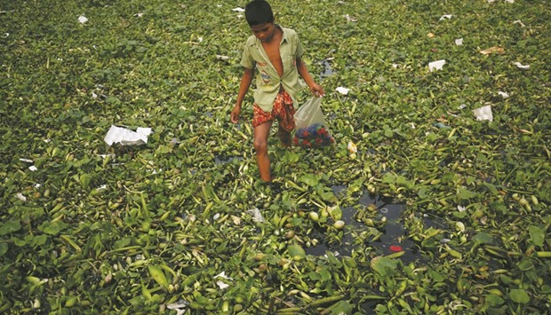 A boy collects plastic waste materials from the Buriganga River to sell to local retailers in Dhaka yesterday.