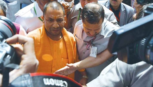 Uttar Pradesh Chief Minister Yogi Adityanath is accompanied by officials as he arrives at the Parliament in New Delhi yesterday.