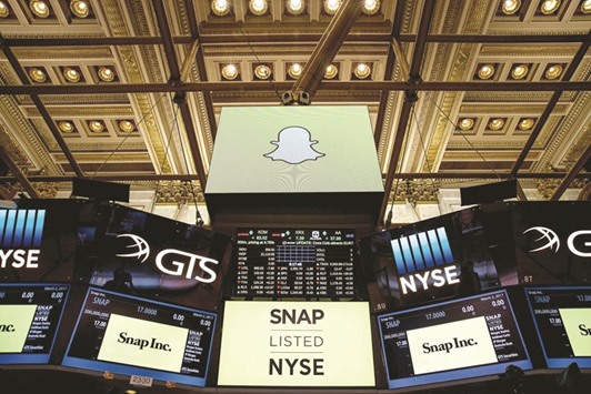 Signage for Snap Inc, parent company of Snapchat, is displayed on monitors on the floor of New York Stock Exchange before the opening bell yesterday. Snap priced its initial public offering at $17 a share on Wednesday.