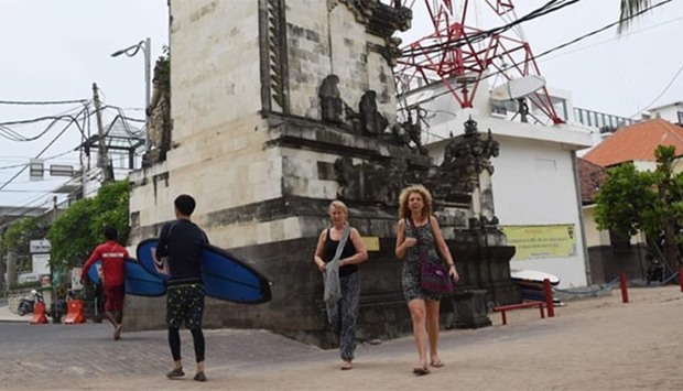 Foreign tourists walk past a tower in Kuta, near Denpasar, on Indonesia's resort island of Bali on Wednesday.