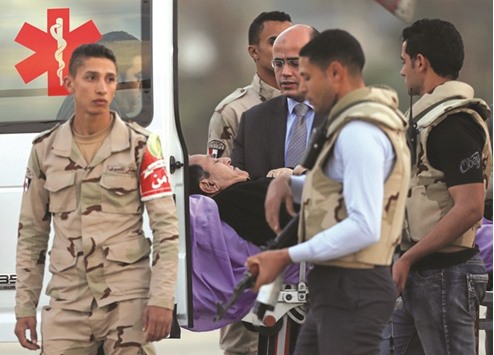 Former president Hosni Mubarak lies on a stretcher after getting back from his trial to the military hospital in Cairo.