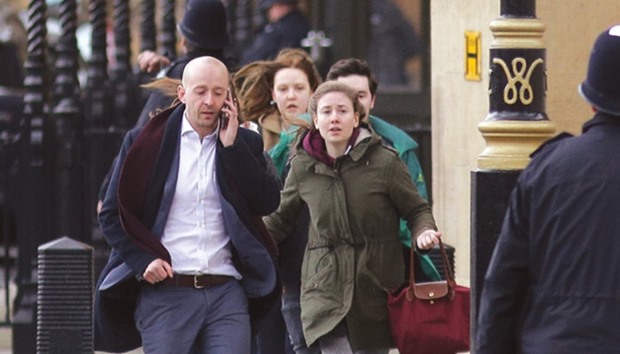 People leave after being evacuated from the Houses of Parliament in central London yesterday. A policeman was stabbed, an assailant shot and several people injured close to the Houses of Parliament in what police said they were treating as a terrorist incident.