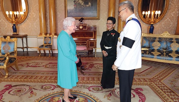 Queen Elizabeth II greets Thailandu2019s ambassador to the United Kingdom, Pisanu Suvanajata, and his wife Thipayasuda Suvanajata, during a private audience at Buckingham Palace in central London.
