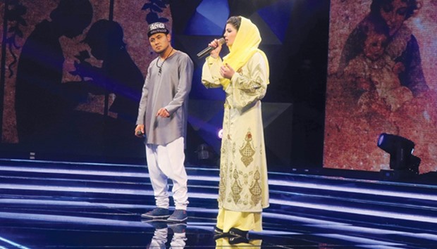 This file photo taken on March 9, 2017 shows young Afghan singer Zulala Hashemi (right) alongside competitor Sayed Jamal Mubarez as they perform during the television music competition Afghan Star.