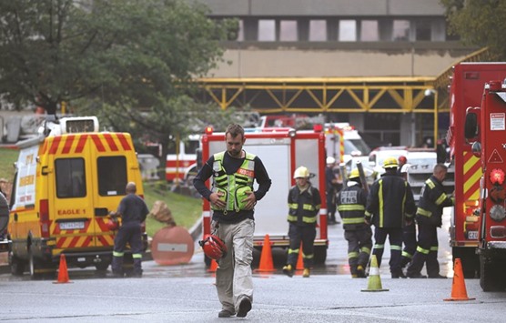 An emergency worker and firefighters are seen at Johannesburgu2019s Charlotte Maxeke state hospital.