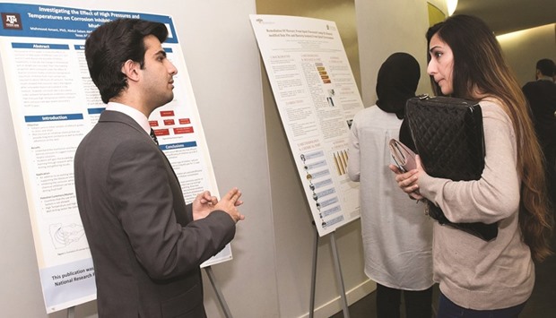 A student discusses his poster at QNRF 9th Annual UREP competition.