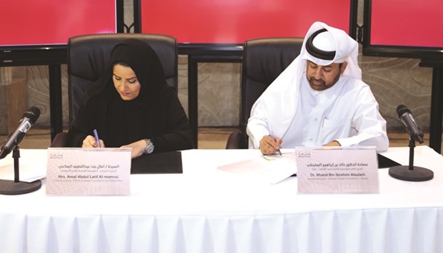 Amal bint Abdullatif al-Mannai and Dr Khalid bin Ibrahim al-Sulaiti signing the MoU yesterday.
