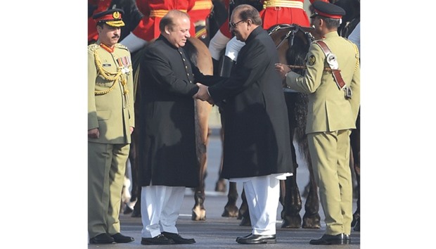 Prime Minister Nawaz Sharif shakes hands with President Mamnoon Hussain during the parade.