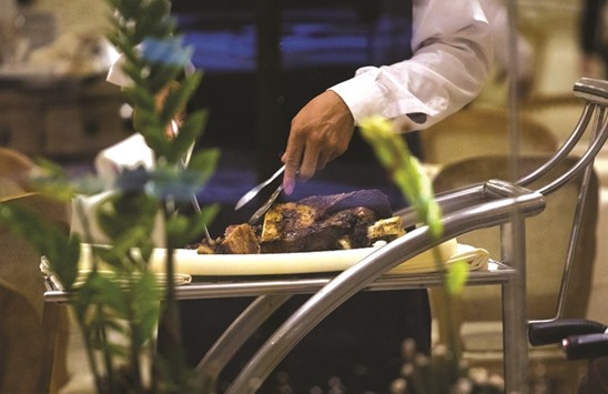 A waiter cuts beef table side at a restaurant in Sao Paulo, Brazil on March 17. Food giants JBS SA and BRF SA, which saw stocks and bonds plunge after being cited by police in the probe, launched a massive ad campaign with full page ads in the biggest newspapers and prime-time television spots assuring consumers their product is safe to eat.
