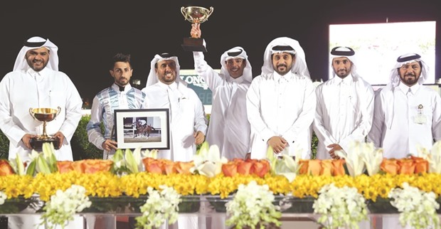 Qatar Racing and Equestrian Club general manager Nasser Sherida al-Kaabi with the winners of the Al Areeq Cup after Karrar won the feature race at the Qatar Racing and  Equestrian Club on Wednesday. PICTURE: Juhaim