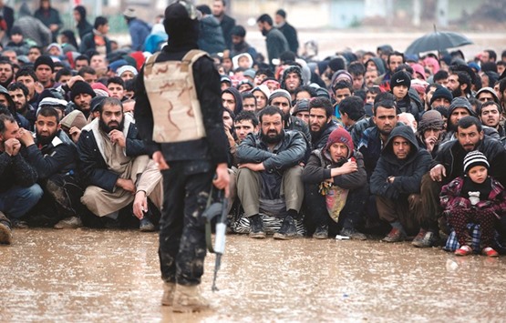Iraqi civilians fleeing the city of Mosul sit in the rain as Iraqi forces advance in their massive operation to retake Iraqu2019s second city from Islamic State militants.