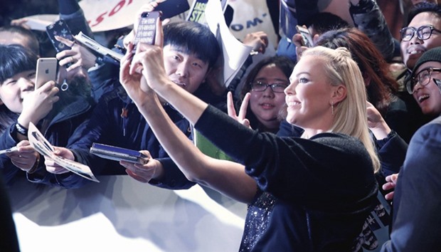 Actor Charlize Theron clicks pictures on the red carpet at a media event for the new film The Fate of the Furious in Beijing, yesterday.
